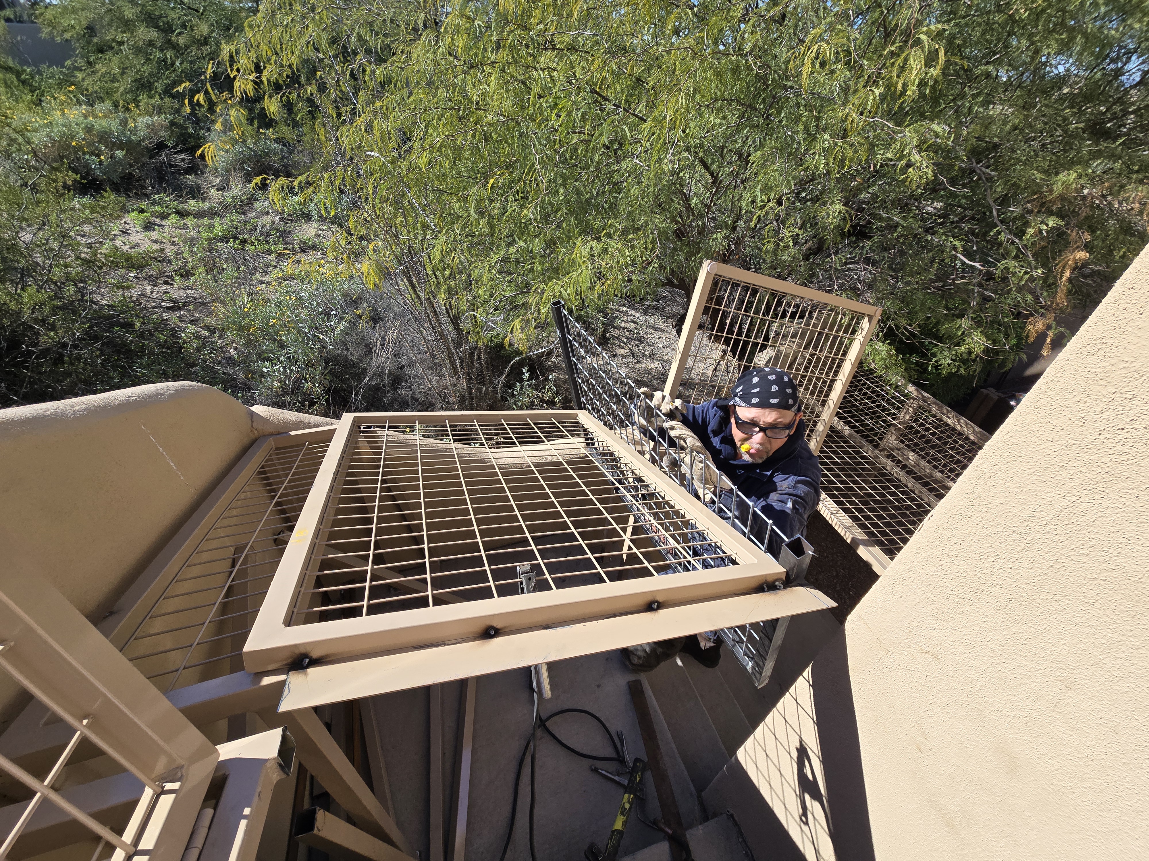 Builder carrying and installing final large wire roof panel